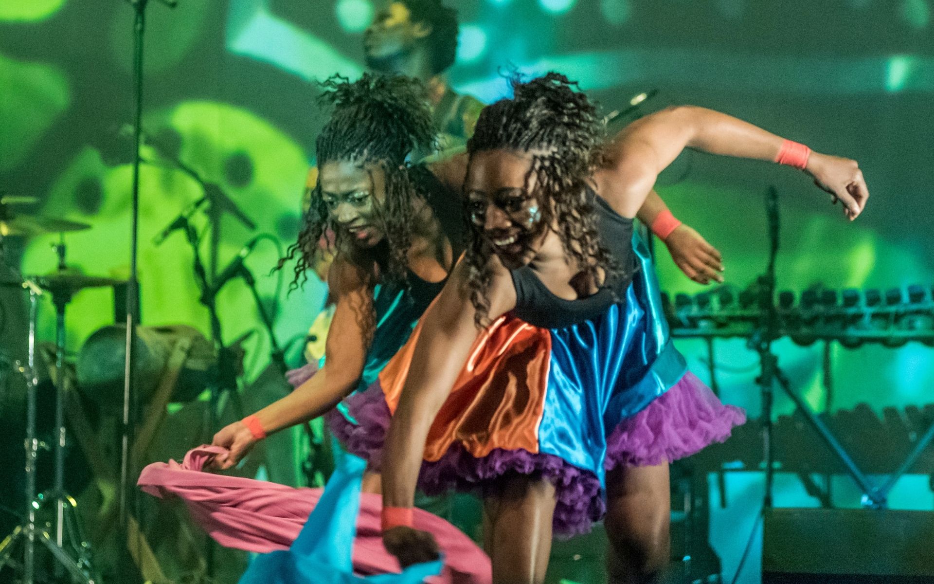 Image of two dancers smiling and waving scarves from the Won’Ma Africa performance on June 1st-5th