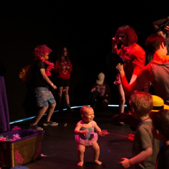 Image of children dancing and smiling with the performers from the Parents are still a Drag performance