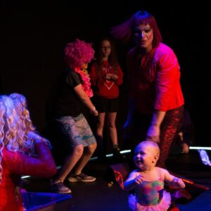 Image of children dancing and smiling with the performers from the Parents are still a Drag performance