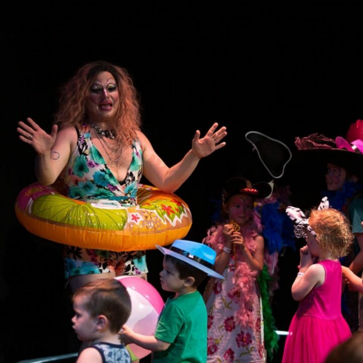 Image of a group of children standing in front of a performer wearing a pool floatie from the Parents are still a Drag performance