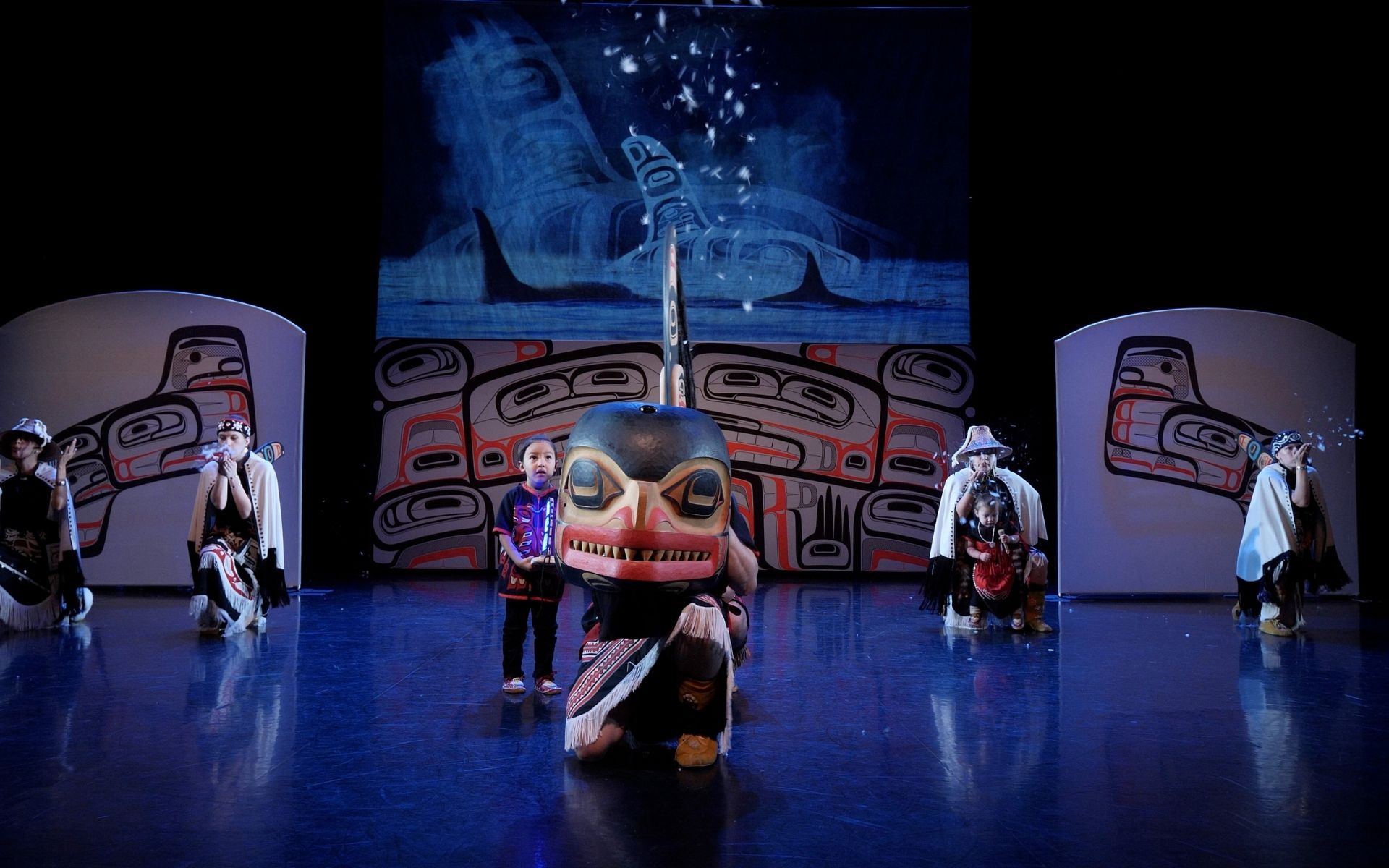 Image of performers from the Spirit and Tradition dance performance on stage kneeling