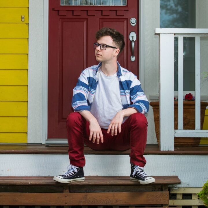 Image of Will Clements sittin on a dront porch. Will is a featured artist in the future artists performance on June 3rd