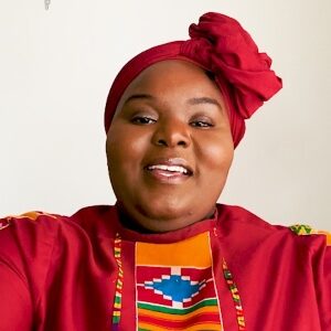 Close up of Black woman wearing traditional African clothing and head wrap. Smiling