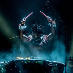 Image of drummer holding drumsticks in the air from the Won’Ma Africa performance on June 1st-5th
