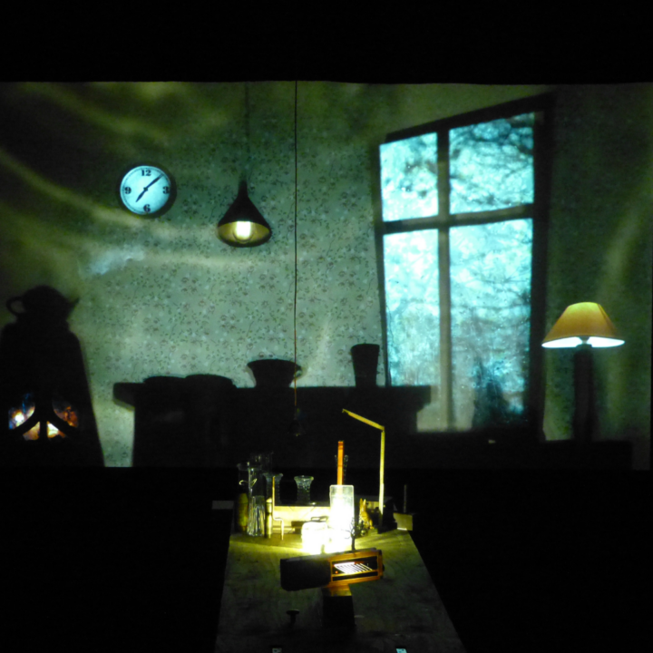 Image of a dark room with a large window for the ‘A Story of a House that Turned into a Dot’ performance