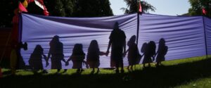 Image of shadows holding hands against a blue sheet