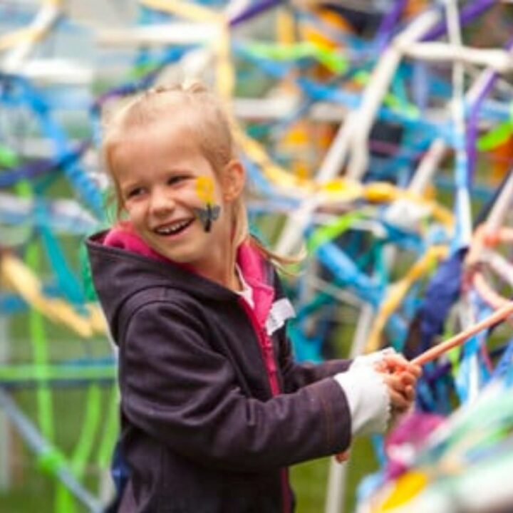 Image of girl smiling and looking behind with facepaint on