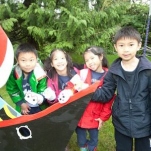 Image of four children smiling, wearing hand puppets