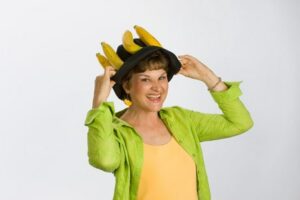 Charlotte Diamond smiling and wearing a black hat with bananas on it