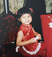 A childhood photo of one of our board members, Christina (Ling Mei) Tang, sitting on a chair and smiling