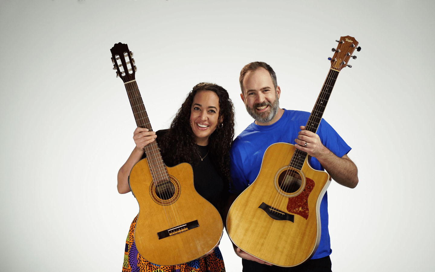 Will and Seeks standing beside each other holding a guitar.