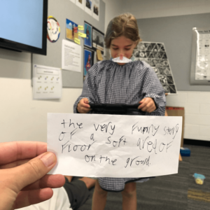 a student in a classroom, and a hand holding a handwritten note