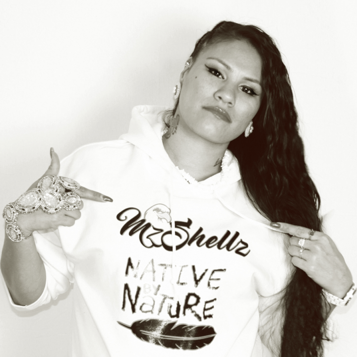 hip hop artist Mz Shellz pointing to her name of her hoodie.