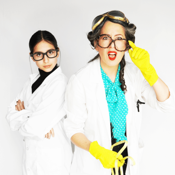 Candice Roberts in a lab coat and wearing gloves standing beside their assistant