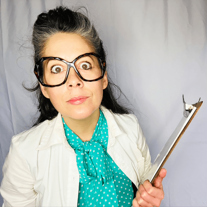 Candice Roberts wearing a blue blouse, a lab coat and holding a clipboard