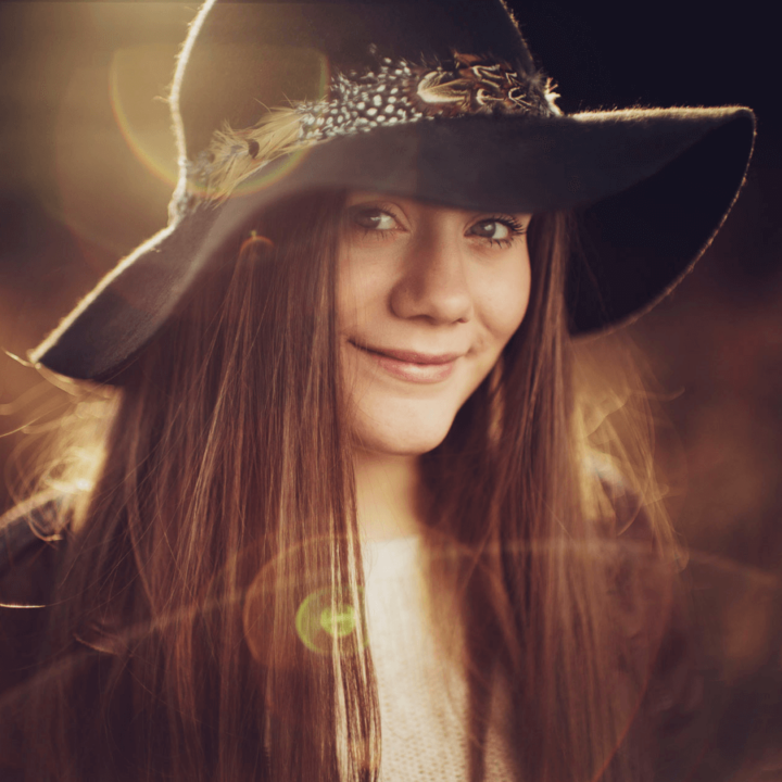 An image of the artist Paige Penny, smiling in the sun.