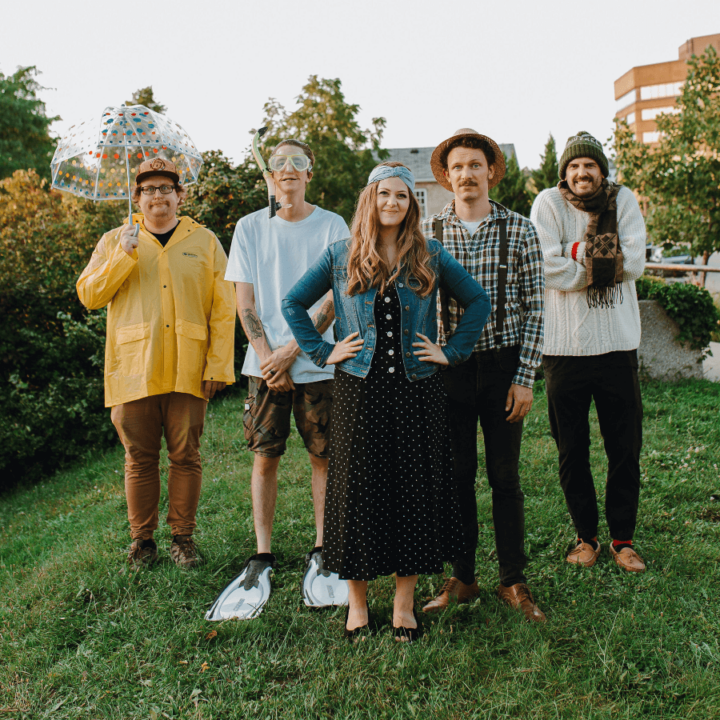 An image of the band members from The Relative Minors standing in the grass smiling.