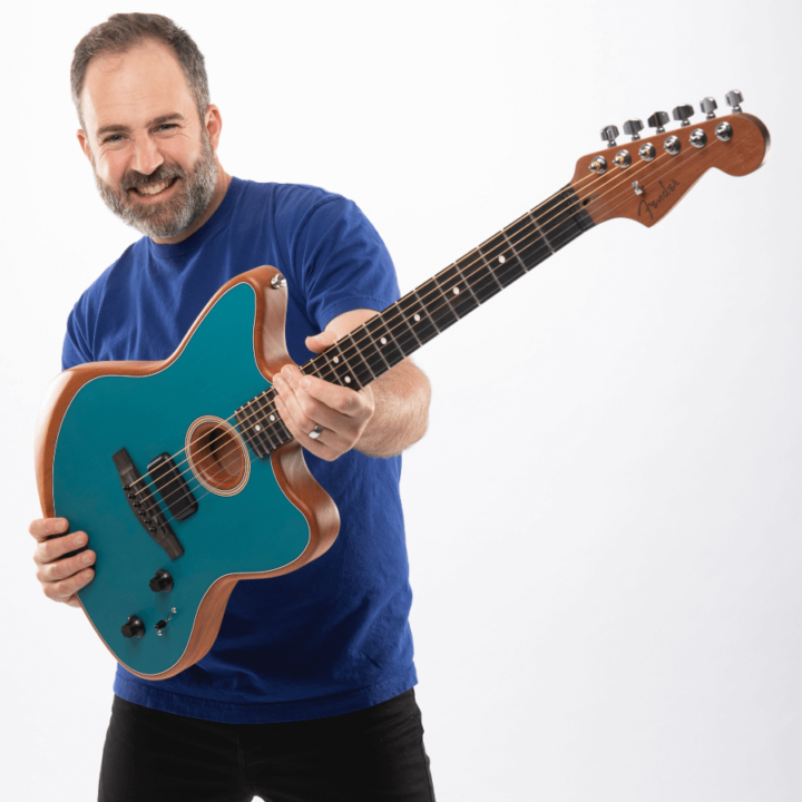 Performer Will, from Will's Jams, holding a blue guitar.