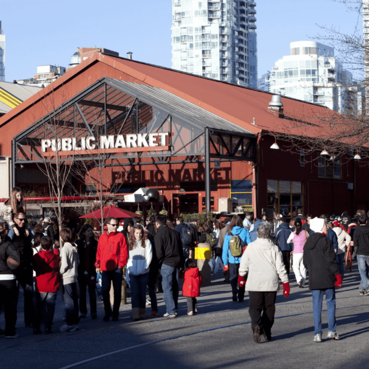 An image of the Public Market entryway on Granville Island, displaying lots of people walking inside.