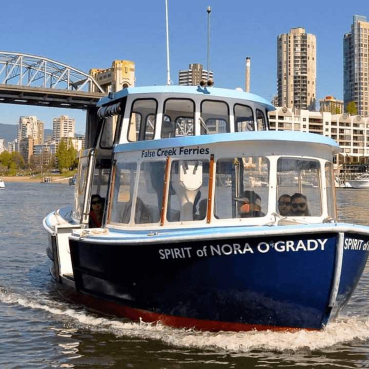 A close up image of a False Creek Ferries boat with the Burrard Bride in the background.