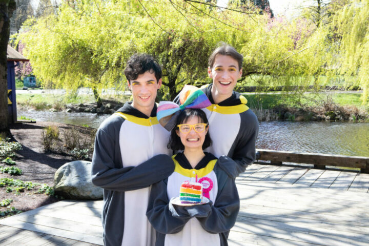 three people dressed up as penguins at a birthday party