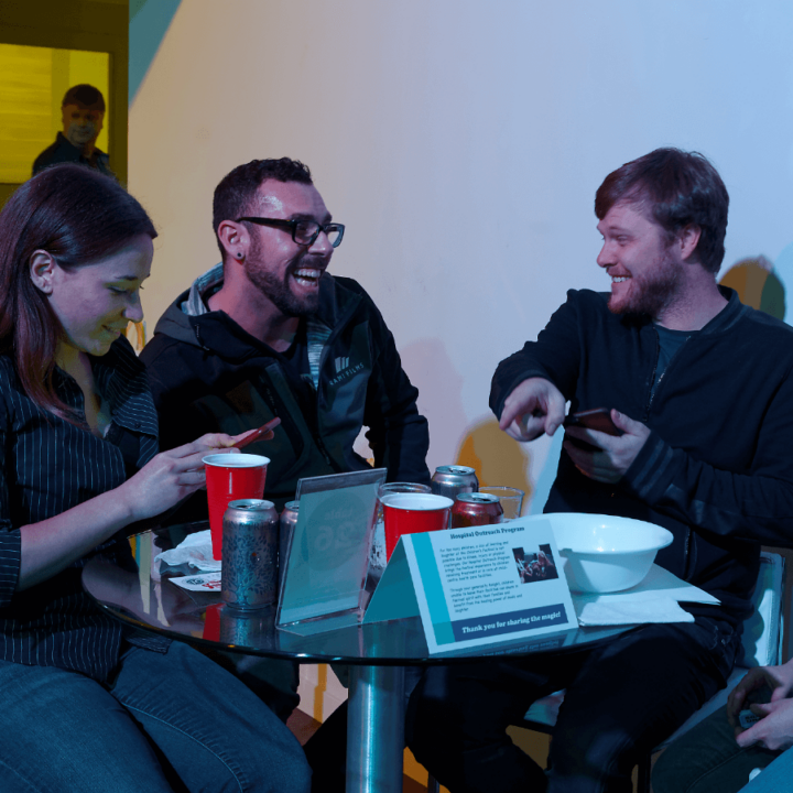 Three people at a table laughing and talking