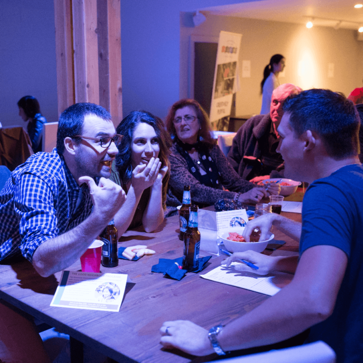 A group of people sitting around a table discussing answers.