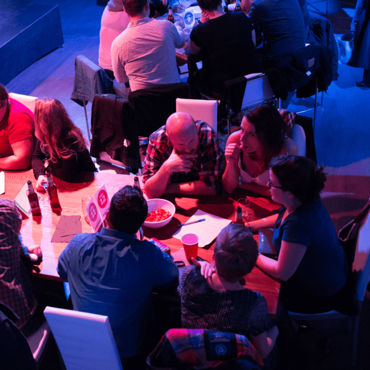 A group of people sitting around a table discussing talking.