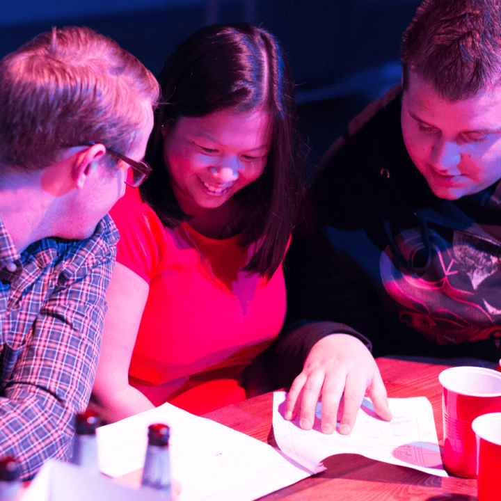 A group of people sitting around a table discussing answers.