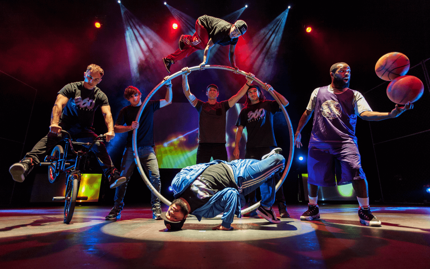A group of people on a stage performing on a hoop.