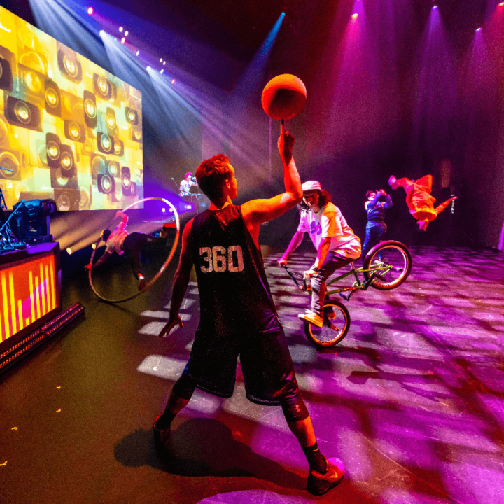 A group of people playing basketball on a stage.