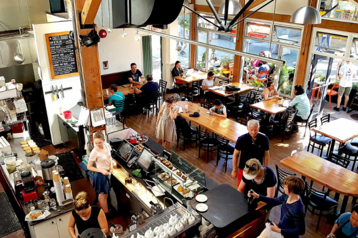 The interior of a bright and busy coffee shop.