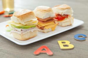 A trio of mini sandwiches on a plate.