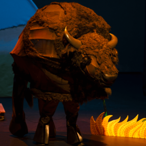 The buffalo stands next to some sweetgrass. There are no little lights in the buffalo now.